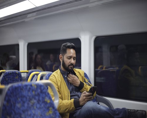 Person commuting on public transport reading a smartphone