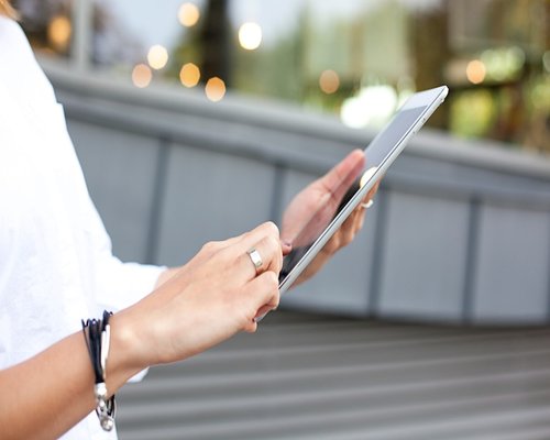 Close up of hands adjusting screen brightness on a tablet device